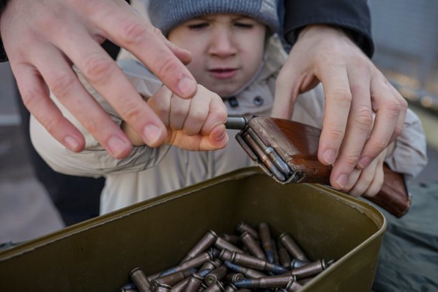 13일(현지시간) 우크라이나 동부 도네츠크의 마리우팔리에서 민간인 기본 전투 교육이 열려 한 소년이 소총 탄피의 실탄을 제거하기 위해 애쓰고 있다. [도네츠크=AP/뉴시스]