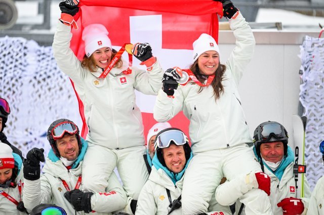 스위스 알파인스키 대표팀 구성원들이 17일 여자 알파인스키 복합에서 나란히 금-은메달을 딴 스위스의 미셸 기신(왼쪽)과 웬디 헐드너(오른쪽)를 목마 태우고 이들의 동반메달을 기념하고 있다.