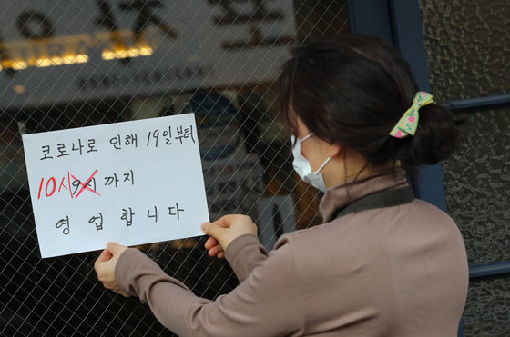 정부가 19일부터 영업시간 제한을 1시간 연장된 오후 10시까지 완화하기로 한 가운데 18일 대전 유성구에 위치한 식당에서 주인이 관련 안내문을 붙이고 있다. 2022.2.18/뉴스1 © News1