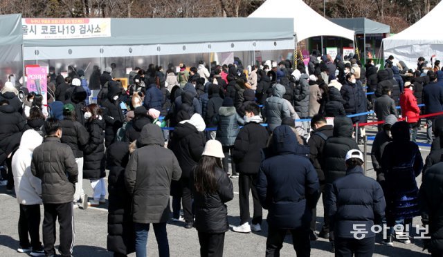 코로나19 확진자 수가 연일 10만명 이상을 기록한 20일 서울 송파구 잠실종합운동장에 마련된 선별진료소에서 시민들이 검사를 받기 위대 차례를 기다리고 있다. 홍진환 기자 jean@donga.com