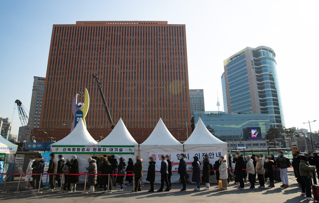 21일 오전 서울 중구 서울역광장에 마련된 임시선별진료소를 찾은 시민들이 검사를 받기 위해 줄을 서 있다. 2022.2.21/뉴스1