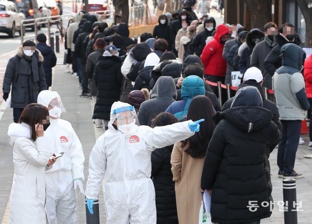 코로나19 누적 확진자가 200만 명을 넘어선 가운데 21일 서울 송파구청 보건소에 마련된 코로나19 임시선별진료소를 찾은 시민들이 코로나19 검사를 기다리고 있다.