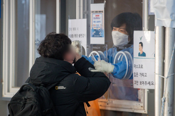 서울 중구 서울역광장에 마련된 선별검사소를 찾은 한 시민이 PCR검사를 위한 검체채취를 하고 있다. 2022.2.22/뉴스1 © News1