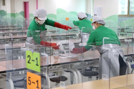 개학을 앞둔 초등학교 급식실에서 관계자들이 비말 차단 가림막을 닦고 있다. 2022.2.22/뉴스1 © News1