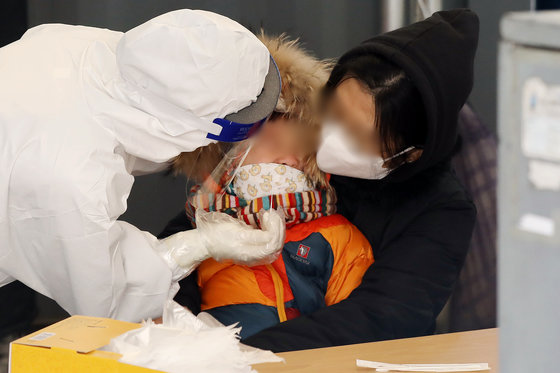 서울 중구 서울역 광장에 마련된 신종 코로나바이러스 감염증(코로나19) 임시 선별검사소를 찾은 한 어린이가 진단 검사를 받고 있다. © News1