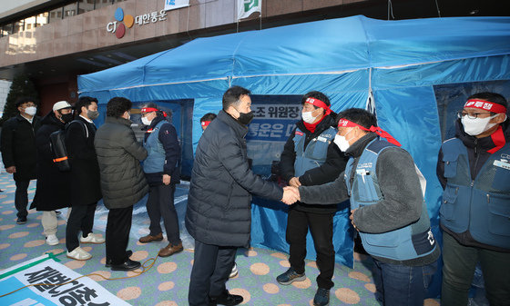 22일 서울시 중구 CJ대한통운 본사 앞 택배노조 파업 농성장에서 전국택배노조 조합원들과 CJ대한통운 대리점연합회 관계자들이 협의 결과를 발표한 뒤 악수 하고 있다. 2022.2.23/뉴스1 © News1