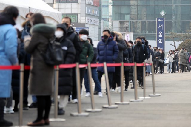 코로나19 신규 확진자가 16만5890명으로 집계된 25일 오전 서울 중구 서울역광장 임시선별검사소에서 시민들이 검사를 받기 위해 대기하고 있다. 뉴시스