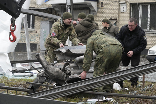 24일(현지 시간) 우크라이나 수도 키예프에서 경찰들이 러시아군의 미사일 포격 후 로켓 잔해를 수습해 트럭에 싣고 있다. 이날 러시아는 키예프뿐 아니라 하리코프, 오데사 등 최소 15개 지역을 공격했다. 키예프=AP 뉴시스