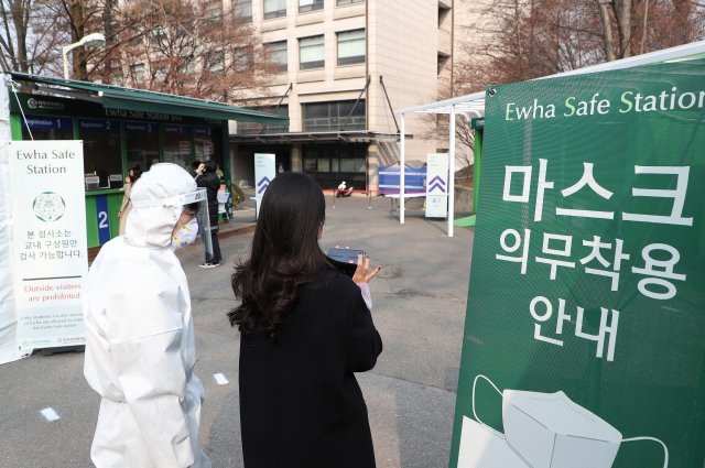 25일 서울 서대문구 이화여대 교내에서 학생들이 코로나19 검사를 받기위해 ‘이화 세이프 스테이션’으로 들어서고 있다.