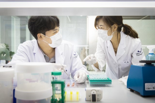 유빅스테라퓨틱스의 이송희 연구소장(오른쪽)이 자사 표적단백질 분해 기술로 실험을 하면서 연구원과 논의를 하고 있다. 유빅스테라퓨틱스 제공
