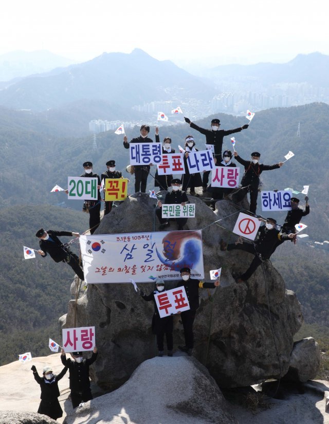 3.1절을 이틀 앞둔 27일 북한산 안전봉사단 단원들이 서울 은평구 북한산 족두리봉 바위에서 3.1절 103주년을 기념하고 열흘 남짓 앞으로 다가온 제20대 대통령선거 투표를 독려하는 퍼포먼스를 펼쳐 보이고 있다.