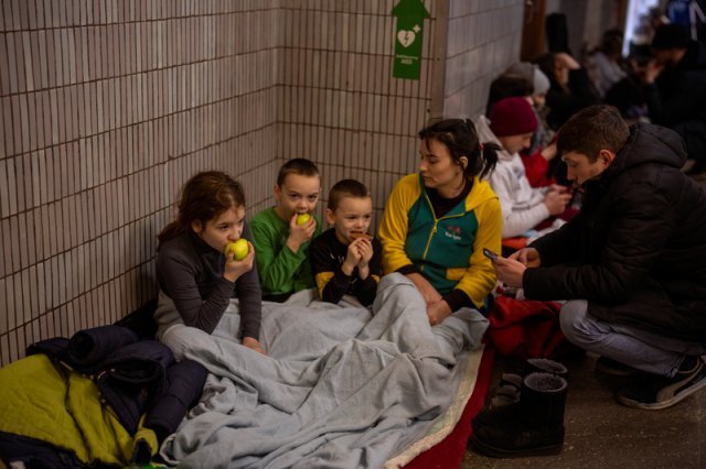 25일(현지시간) 우크라이나 수도 키예프에서 한 가족이 방공호로 사용 중인 키예프 지하철역 구내에 대피해 과일을 먹고 있다. AP/뉴시스