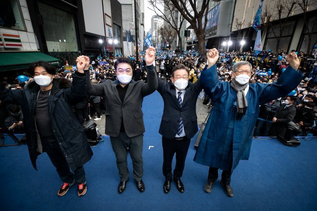 더불어민주당 이재명 대선 후보(오른쪽에서 두 번째)가 지난 1일 서울 중구 명동 눈스퀘어 앞에서 열린 ‘3·1 정신으로 여는 대한민국 대전환!’ 유세에서 유홍준 전 문화재청장, 배우 이원종 박혁권(오른쪽부터)과 손을 맞잡고 지지를 호소하고 있다. 사진공동취재단