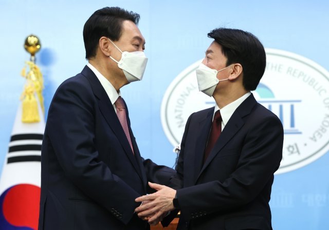 윤석열 국민의힘 대선 후보와 안철수 국민의당 대선 후보가 3일 서울 여의도 국회 소통관에서 단일화 기자회견을 마치고 손을 잡고 있다. 사진공동취재단