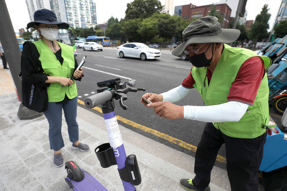 15일 오전 서울 송파구 가락시장역 인근에서 송파구청 관계자들이 불법 주·정차 전동킥보드를 단속 및 견인하고 있다. 2021.7.15/뉴스1
