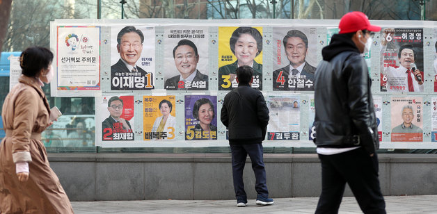 제20대 대통령 선거 사전투표를 하루 앞둔 3일 오후 서울 종각옆 앞에서 유권자들이 후보들의 선거벽보를 살펴보고 있다. 2022.3.3/뉴스1