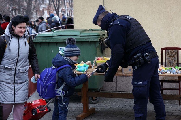 3일(현지시간) 우크라이나 접경 도시인 폴란드 프셰미실 중앙역에서 경찰이 우크라이나 수도 키이우에서 열차를 타고 온 피란 아동에게 과자를 건네고 있다. 2022.3.4/뉴스1 © News1