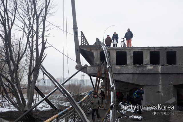 우크라이나 수도 키이우 북쪽 외곽 소도시 이르핀에서 파괴된 다리를 바라보고 있는 시민들. ⓒ(GettyImages)/코리아