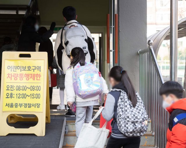 사흘간 어린이-청소년 확진 2만명 육박… 불안한 등굣길 코로나19 하루 신규 확진자가 21만 명을 넘어선 7일 서울의
 한 초등학교에서 학생들이 등교하고 있다. 이날 서울시교육청에 따르면 주말을 낀 4∼6일 사흘 동안 서울에서만 유치원생과 
초중고교생 1만974명이 코로나19에 확진됐다. 뉴스1