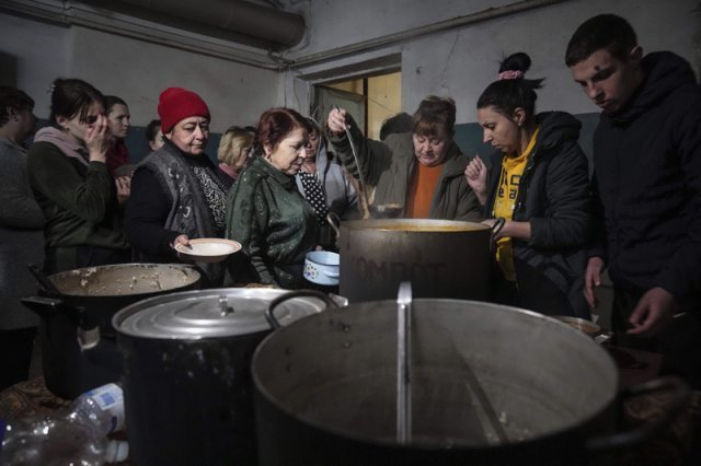 8일(현지시간) 우크라이나 마리우폴의 임시 방공호에 대피한 주민들이 더운 음식 배급을 받고 있다. 사진 AP 뉴시스