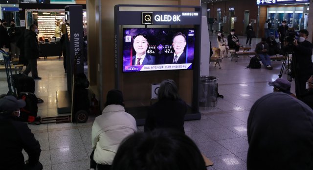 제20대 대통령 선거 투표일인 9일 오후 서울 중구 서울역에서 유권자들이 방송3사 출구조사 결과를 지켜보고 있다. 2022.3.9/뉴스1