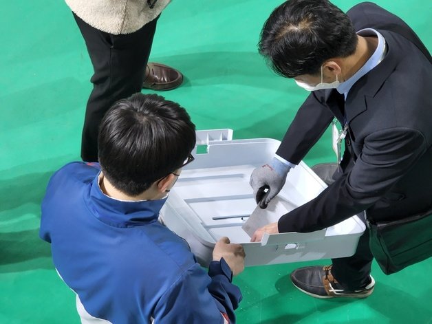 충남 천안시 서북구 개표소에서 개함을 마친 투표함 뚜껑에 낀 투표용지를 선관위 직원이 꺼내고 있다.© 뉴스1