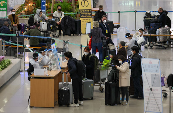 6일 인천국제공항 1터미널 입국장에서 해외입국자들이 여권을 보여주고 있다. 2022.3.6/뉴스1