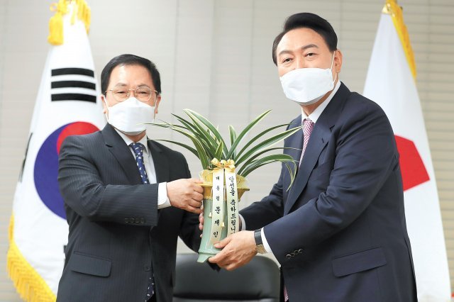 文대통령 축하 난 전달 윤석열 대통령 당선인(오른쪽)이 유영민 대통령비서실장으로부터 문재인 대통령이 전한 축하 난을 전달받으며 포즈를 취하고 있다. 사진공동취재단