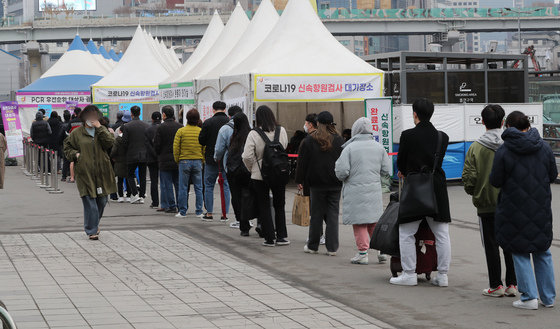 12일 서울 중구 서울역광장에 마련된 선별진료소를 찾은 시민들이 신종 코로나 바이러스 감염증(코로나19) 검사를 받기 위해 줄을 서 있다. 뉴스1