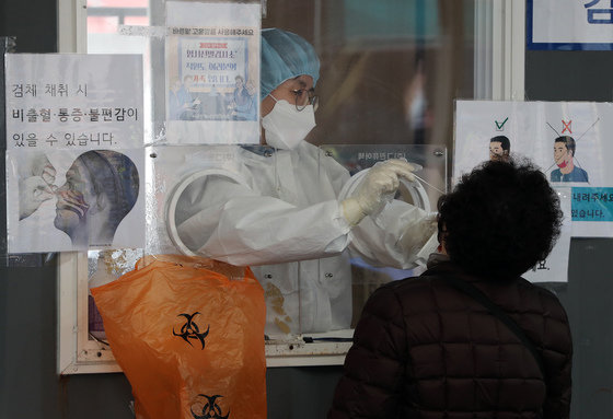 서울 중구 서울역광장에 마련된 선별진료소를 찾은 시민이 신종 코로나 바이러스 감염증(코로나19) 검체 검사를 받고 있다. 2022.3.12/뉴스1 © News1