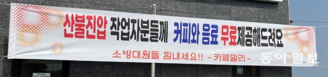 12일 경북 울진군 죽변면의 한 카페에 ‘산불 진화대원에게 커피와 음료를 무료로 제공한다’는 플래카드가 걸려 있다. 울진 지역에선 이 카페처럼 진화대원을 응원하기 위해 식사 등을 무상으로 제공하겠다는 자영업자들이 잇따랐다. 울진=김윤이 기자 yunik@donga.com