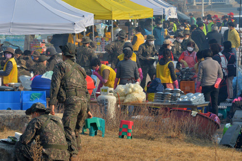 적십자의 끝없는 봉사 울진 산불 엿새째인 9일 오전 경북 울진군 죽변면 봉평리 산불현장대책본부에 마련된 경북도 적십자 재난구호급식소에서 자원봉사원들이 진화 대원들을 위한 식사를 준비하고 있다.