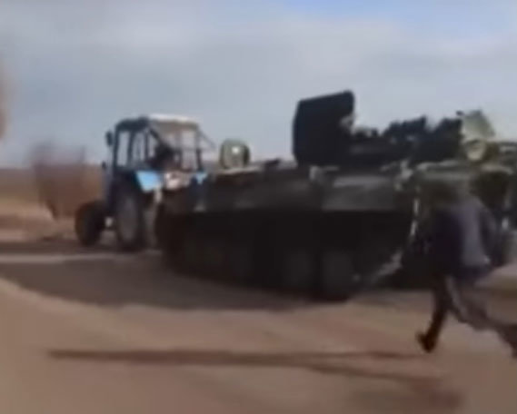 우크라이나 농부의 트랙터에 끌려가는 러시아군 장갑차를 한 러시아 군인이 황급히 뒤쫓아 가고 있다. 유튜브 캡처