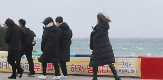 제주시 용담해안도로에서 관광객들이 강한 바람을 맞으며 발걸음을 옮기고 있다. 2021.11.22/뉴스1 © News1 오현지 기자