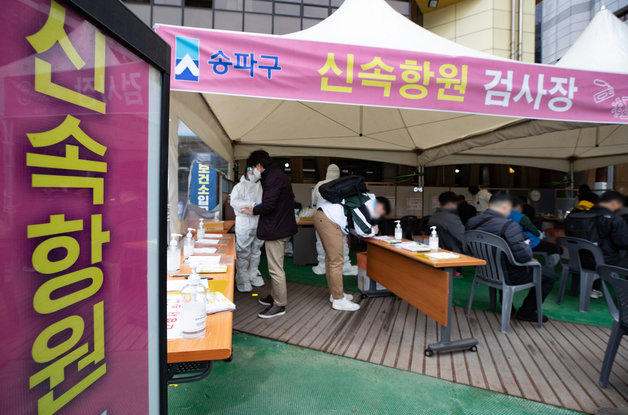 18일 오전 서울 송파구보건소에 마련된 선별진료소에서 시민들이 신속항원 검사 신청서를 작성하고 있다. 2022.3.18/뉴스1
