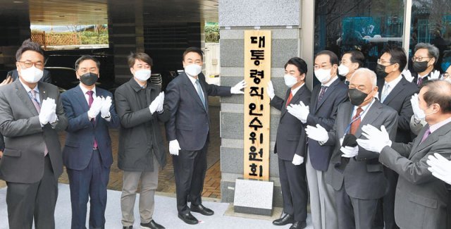 대통령직인수위 현판식 윤석열 대통령 당선인(왼쪽에서 네 번째)과 안철수 대통령직인수위원회 위원장(오른쪽에서 네 번째)
 등이 18일 서울 종로구 통의동 인수위에서 열린 현판식에 참석했다. 현판은 2013년 윤 당선인이 수원지검 여주지청장 근무 당시
 여주지청의 현판을 제작했던 서예가 운학 박경동 선생이 소나무를 깎아 만들었다. 윤 당선인은 이날 인수위 첫 전체회의에서 “새 
정부 국정과제의 모든 기준은 국민과 국익이 우선돼야 한다”고 당부했다. 사진공동취재단