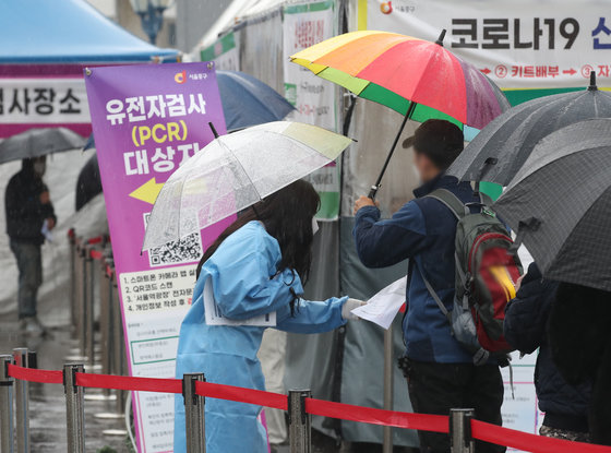 19일 서울 중구 서울역 앞 신종 코로나바이러스 감염증(코로나19) 선별진료소에서 의료진이 검체검사를 받기 위해 줄 선 시민들을 안내하고 있다. 질병관리청 중앙방역대책본부는 이날 0시 기준 신규 확진자가 38만1,454명 발생했다고 밝혔다. 위중증 환자는 전날과 같은 1,049명이며, 사망자 수는 319명으로 전날보다 18명 늘었다. 2022.3.19/뉴스1 © News1