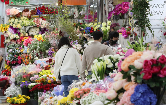 봄 날씨를 보인 16일 서울 서초구 양재꽃시장을 찾은 시민들이 꽃을 고르고 있다. 2022.3.16/뉴스1