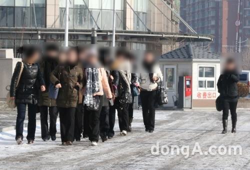 2013년 2월 6일 오전 중국 랴오닝성 단둥시의 거리를 북한 여성 근로자들이 줄을 맞춰 걸어가고 있다. 북한이 외화벌이를 위해 운영하는 식당에서 일하는 여성들인 이들은 근처 숙소에서 합숙생활을 하고 있는 것으로 보인다. 기사와 직접적 관련 없는 참고사진. 동아일보DB