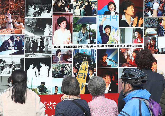 박근혜 전 대통령 귀향과 입주를 하루 앞둔 23일 오후 지지자들이 사저 앞 게시대에 전시된 박 전 대통령 사진을 살펴보고 있다. 2022.3.23/뉴스1