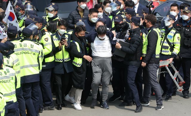 24일 오후 대구 달성군 유가읍 박근혜 전 대통령 사저 앞에서 소주병을 던진 한 시민이 연행되고 있다. 뉴시스