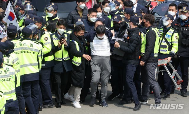 24일 오후 대구 달성군 유가읍 박근혜 전 대통령 사저 앞에서 한 시민이 연행되고 있다. 연행되는 시민은 인사말을 하는 박근혜 전 대통령에게 소주병을 던진 것으로 알려졌다. 뉴시스