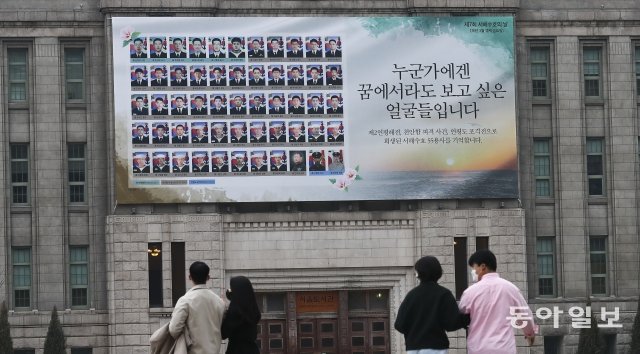 제7회 서해수호의 날을 하루 앞둔 24일 서울 중구 서울도서관 외벽에 서해 수호 55용사의 얼굴 사진과 추모 문구가 걸려 있다. 서해수호의 날은 제2연평해전과 천안함 피격, 연평도 포격전 희생자를 추모하는 기념일이다. 원대연 기자 yeon72@donga.com