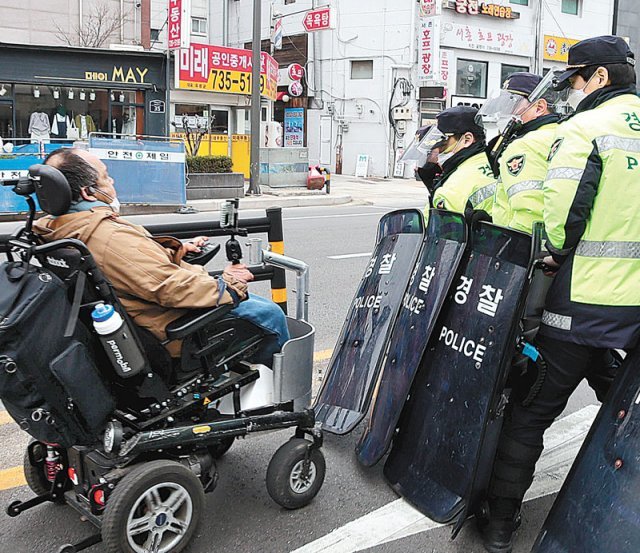 휠체어를 탄 전국장애인차별철폐연대 소속 장애인이 25일 오전 서울 경복궁역 인근 도로에서 시위를 벌이고 있다. 뉴시스