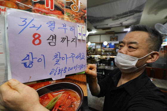 사회적 거리두기가 완화된 21일 서울 종로구의 한 음식점에서 관계자가 거리두기 관련 안내문을 붙이고 있다. 2022.3.21/뉴스1