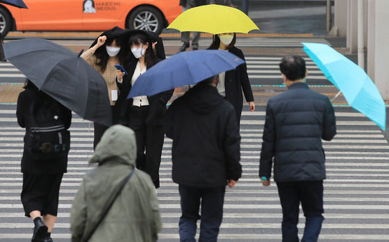 14일 오후 서울 영등포구 여의도 일대에서 시민들이 내리는 봄비에 우산을 쓰며 걷고 있다. 2022.3.14/뉴스1 © News1