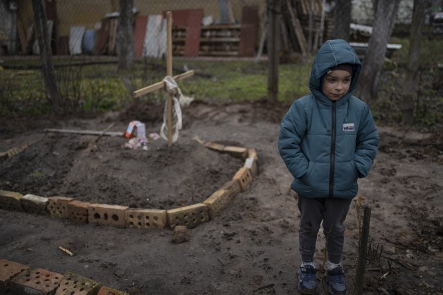 4일 우크라이나 키이우 외곽에서 6살 소년 블래드 타뉘크가 집 마당에 묻힌 엄마의 무덤 옆에 서 있다. 소년의 엄마는 전쟁 이후 굶주림에 시달리다 숨진 것으로 전해졌다.