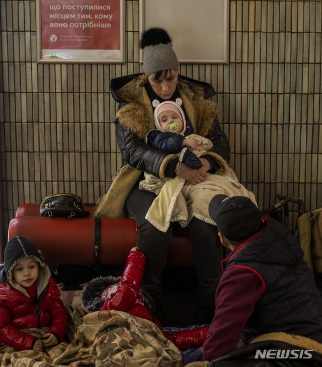 2월 25일 우크라이나 수도 키이우의 한 지하철역 벤치 주변에 한 가족이 대피해있다.  배고픔에 지친 어린 자녀들이 축 처져있다.