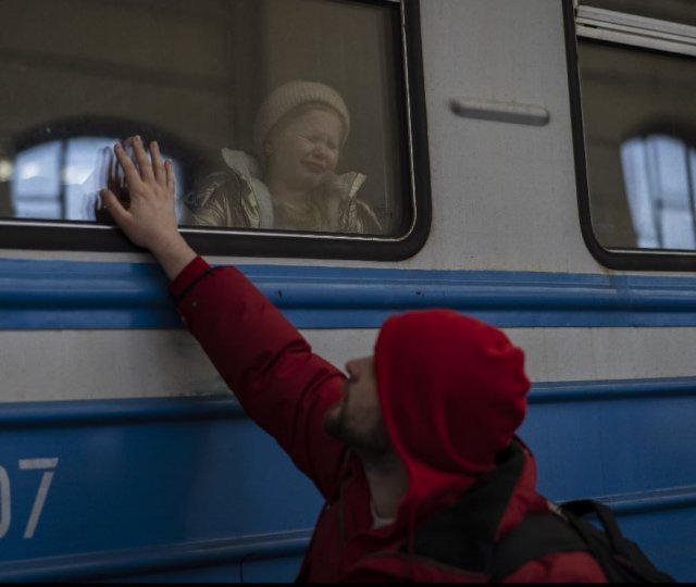 지난달 22일 우크라이나 서부 르비우역에서 한 남성이 폴란드행 열차에 어린 자녀를 태운 뒤 작별인사를 하고 있다. 아이는 아버지가 손을 흔들자 울음을 터트렸다.