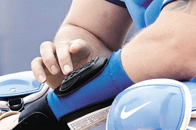 메이저리그 시범경기에서 한 포수가 사인 전달용 전자기기 ‘피치컴’을 통해 투구 사인을 내고 있다. AP 뉴시스